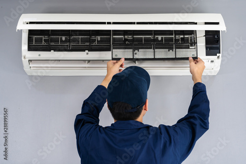 technician service removing air filter of air conditioner for cleaning