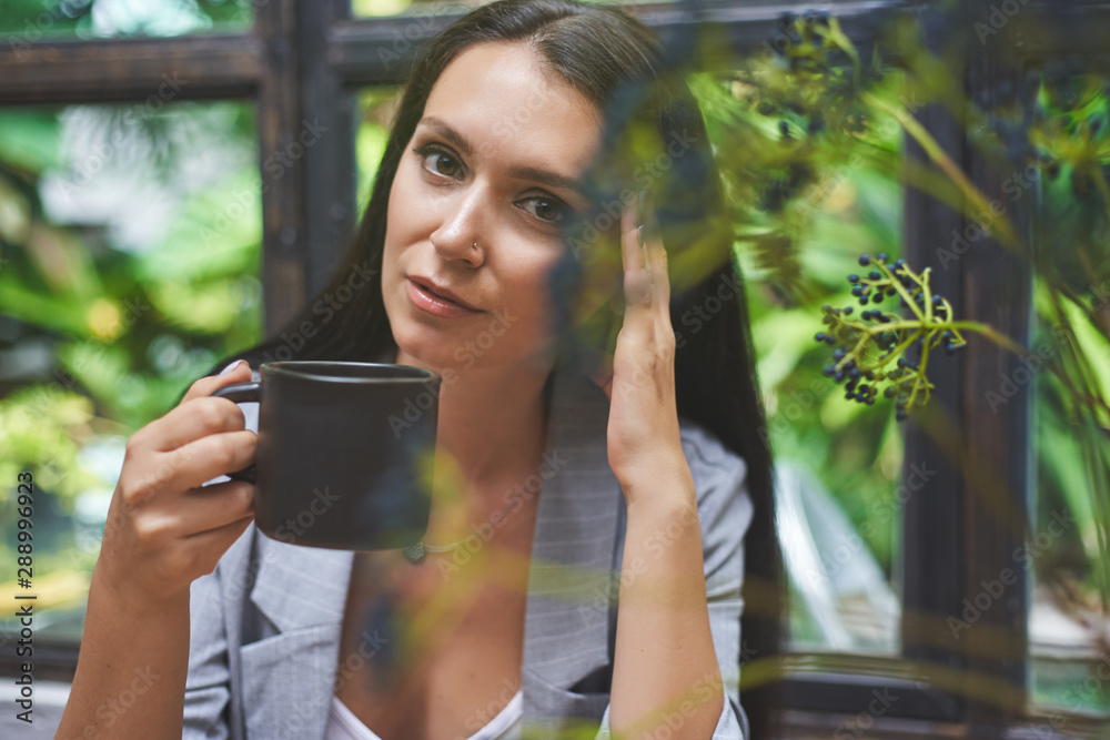 Young woman close up portrait with natural light with cup of coffee in hand Young woman close up portrait with natural light with cup of coffee in hand