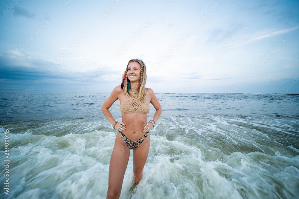 Beautiful young woman in bikini is coming out of the ocean on tropical beach  Stock Photo