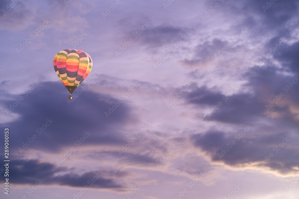 Obraz premium Colorful hot air balloon with dramatic sky at sunset