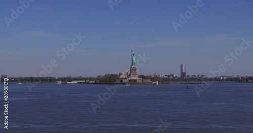 Liberty Lady holds the torch in her right hand on the Liberty Island in the New York Harbor in a sunny summer day. photo