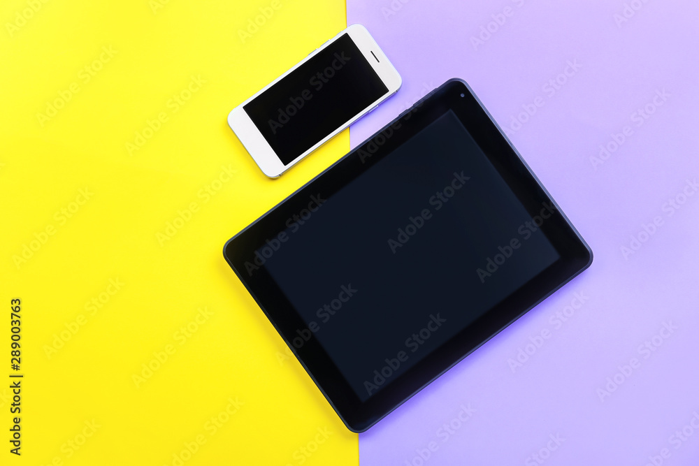 Modern tablet computer with mobile phone on color background Modern tablet computer with mobile phone on color background