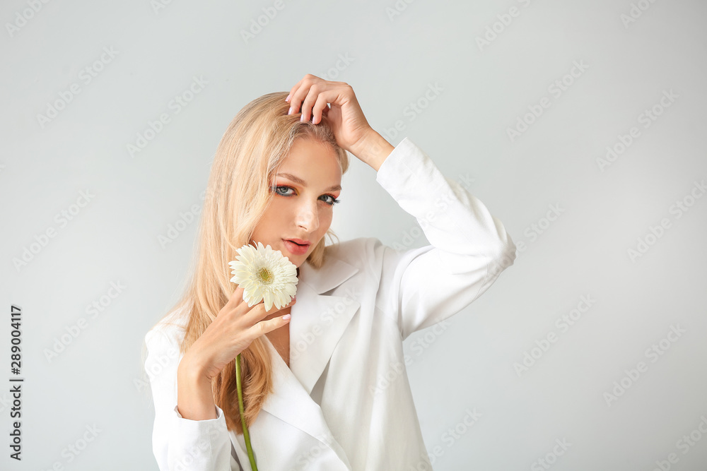 Beautiful young woman with gerbera flower on white background Beautiful young woman with gerbera flower on white background