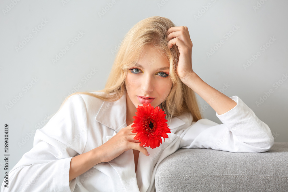 Beautiful young woman with gerbera flower on white background Beautiful young woman with gerbera flower on white background