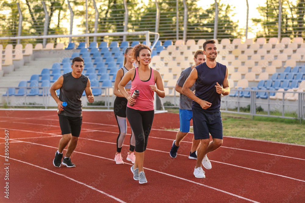 Sporty young people running at the stadium