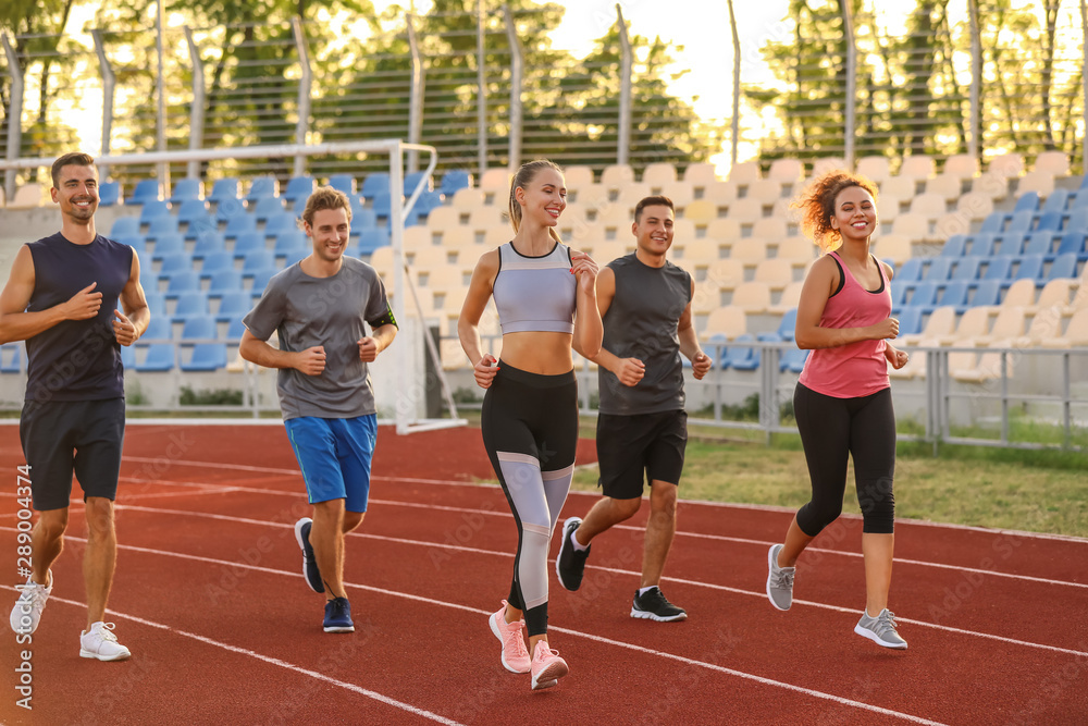 Fototapeta premium Sporty young people running at the stadium
