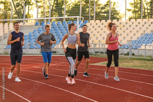 Sporty young people running at the stadium