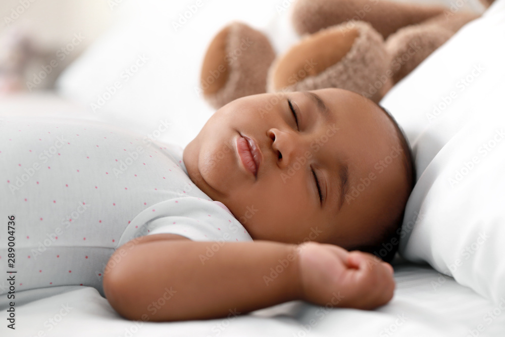 Cute African-American baby sleeping on bed - obrazy, fototapety, plakaty 