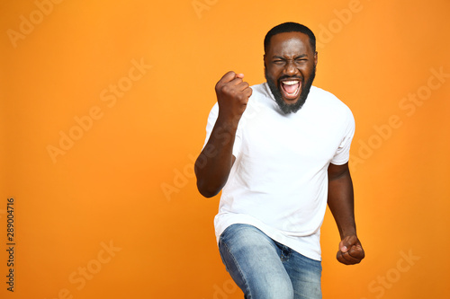 Happy African-American man on color background photo