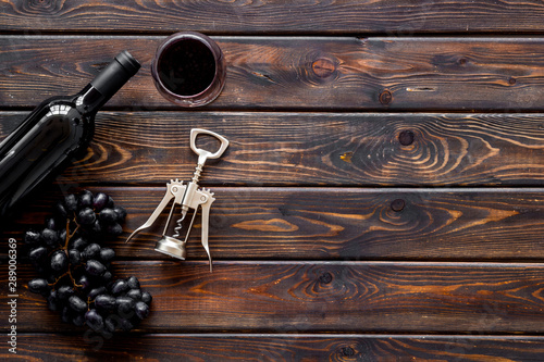 Open wine bottle. Top view dark wooden background copy space