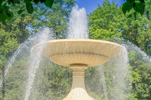 Fountain in the city park. A fountain in the form of a yellow stone bowl.