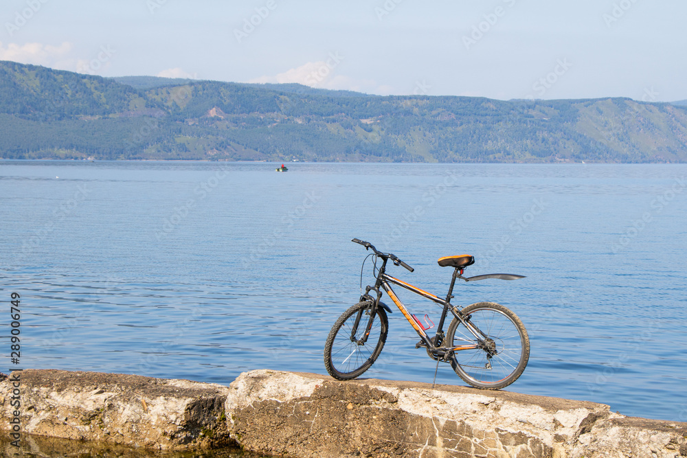 Bicycle standing on stones against backdrop of Lake Baikal.