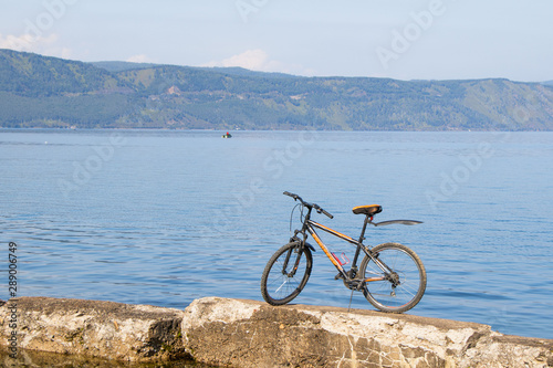 Bicycle standing on stones against backdrop of Lake Baikal.