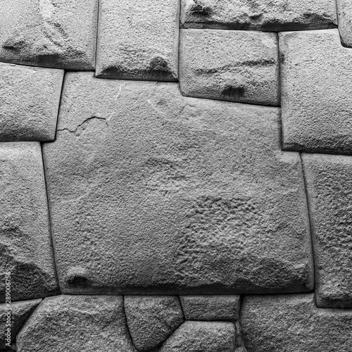 Square black and white photograph of the famous twelve angle stone in the Hatun Rumiyoc street in the historic city center of Cusco, Peru. photo