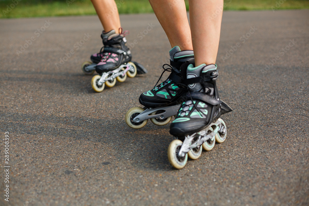 legs of sports girls on a roller skate walk