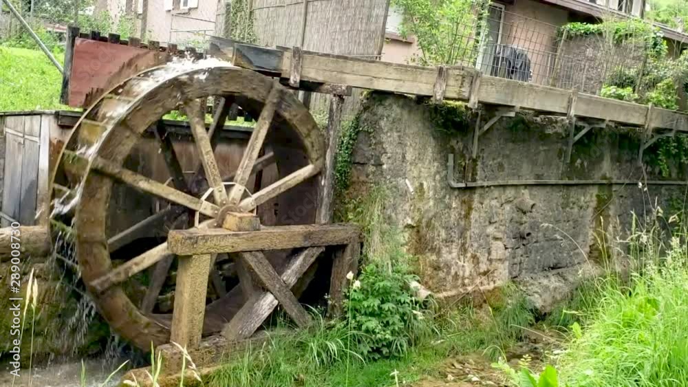 Wooden Vertical Water Wheel Powers a Grist Mill in Switzerland with Flowing Waters Wooden Vertical Water Wheel Powers a Grist Mill in Switzerland with Flowing Waters