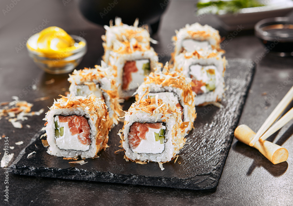Macro shot of uramaki sushi rolls with cream cheese, salmon, tuna shavings or dried bonito, cucumber, nori. Portion of fresh katsuobushi roll in Japanese restaurant closeup Macro shot of uramaki sushi rolls with cream cheese, salmon, tuna shavings or dried bonito, cucumber, nori. Portion of fresh katsuobushi roll in Japanese restaurant closeup
