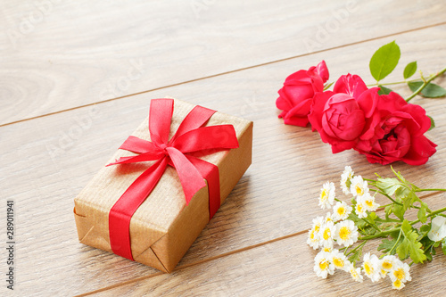 Gift box on wooden boards with flowers