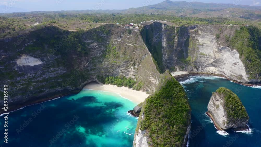 Aerial view of the beautiful Kelingking beach bay with blue turquoise water between rocky mountains on Bali, Indonesia. Aerial view of the beautiful Kelingking beach bay with blue turquoise water between rocky mountains on Bali, Indonesia.