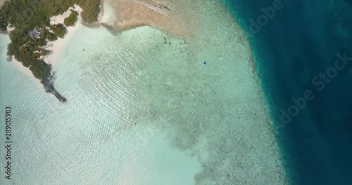 Aerial top down view of the beautiful island with turquoise tropical indian water of the ocean on the maldives. Nature paradise landscape shot. photo