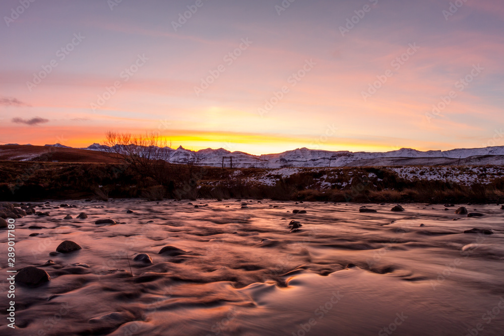 dramatic golden sunset over snow covered mountain range