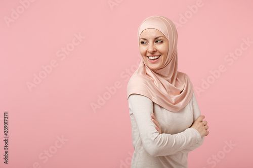 Photography Laughing young arabian muslim woman in hijab light clothes posing isolated on pink wall background