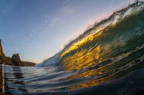 golden sunset reflection on a breaking wave