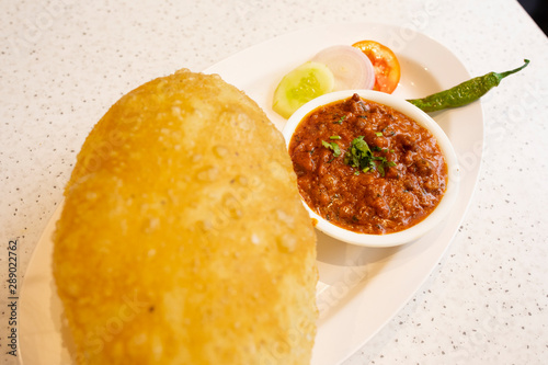 Indian Cuisine Chole Bhature Also Know as Chick Pea Curry, Chole Bhture or Chola/Chana Masala Served With Fried Puri is a Dish From The Punjab photo