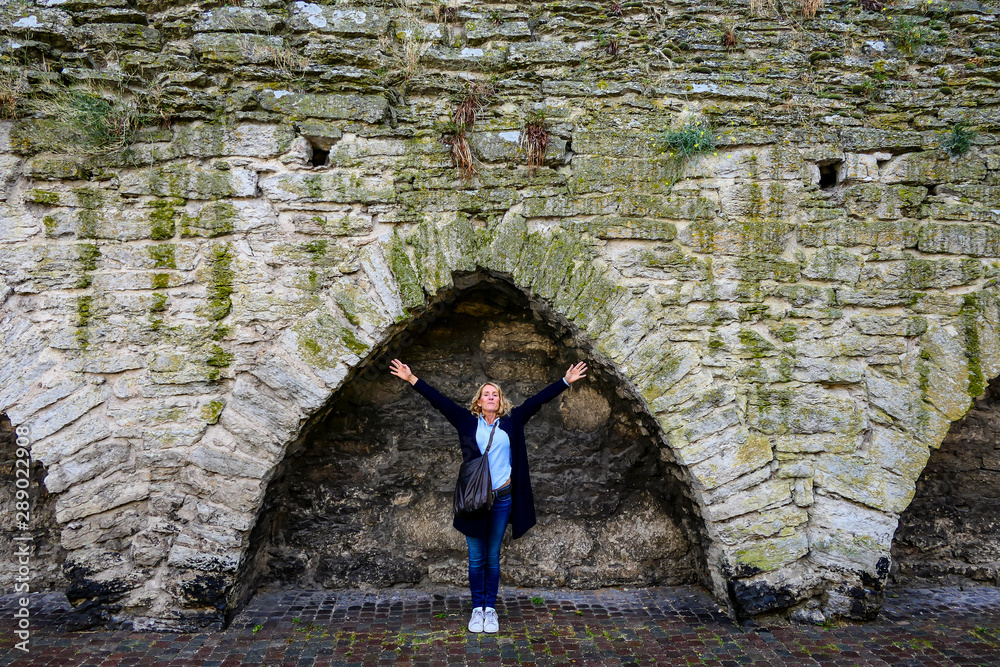Φωτογραφία Visby, Gotland, Sweden A woman stretches her arms under the Visby City defensive Wall with crenellations from the 12th century