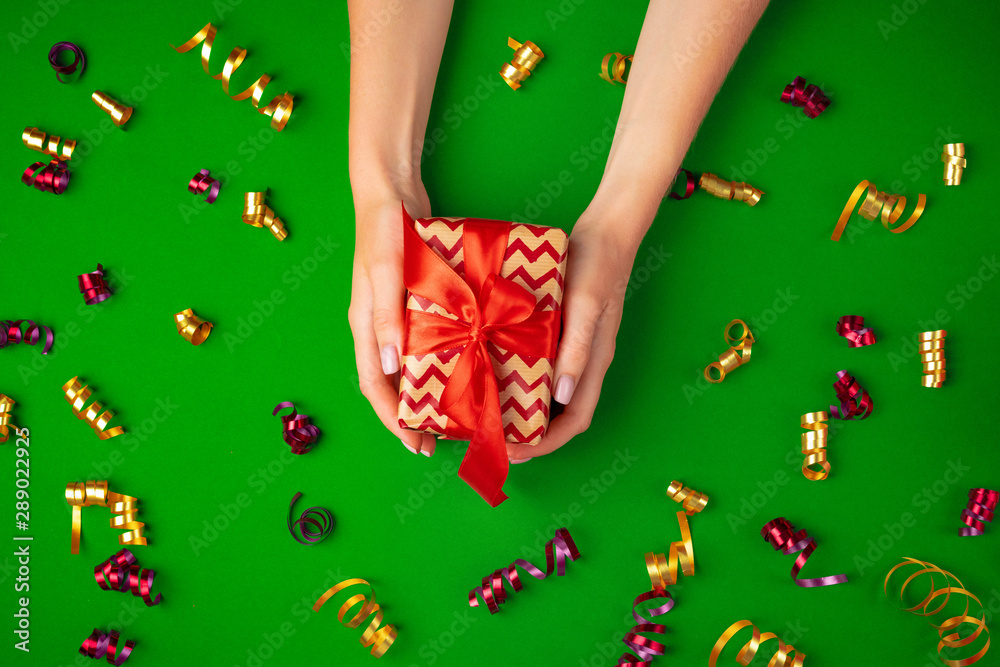 Woman hands holding gift box top view