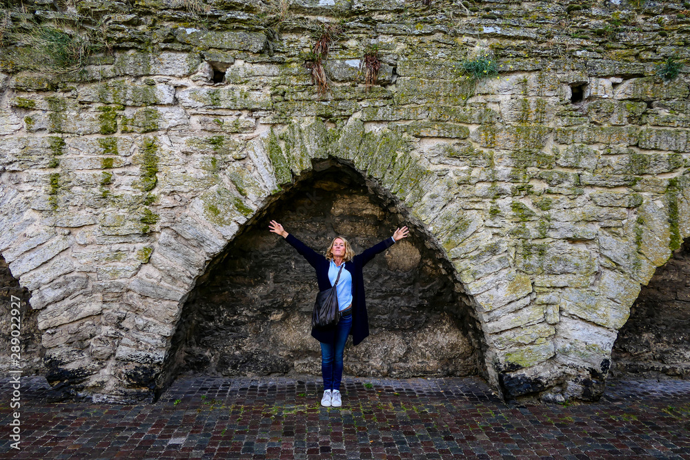Φωτογραφία Visby, Gotland, Sweden A woman stretches her arms under the Visby City defensive Wall with crenellations from the 12th century