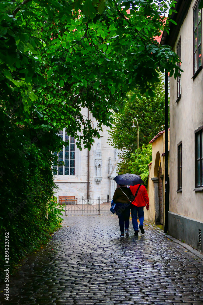Visby, Gotland, Sweden A couple walk on the back streets of the medieval cityin the rain.
