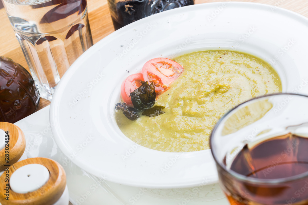 bowl of broccoli and green peas cream soup on wooden table bowl of broccoli and green peas cream soup on wooden table