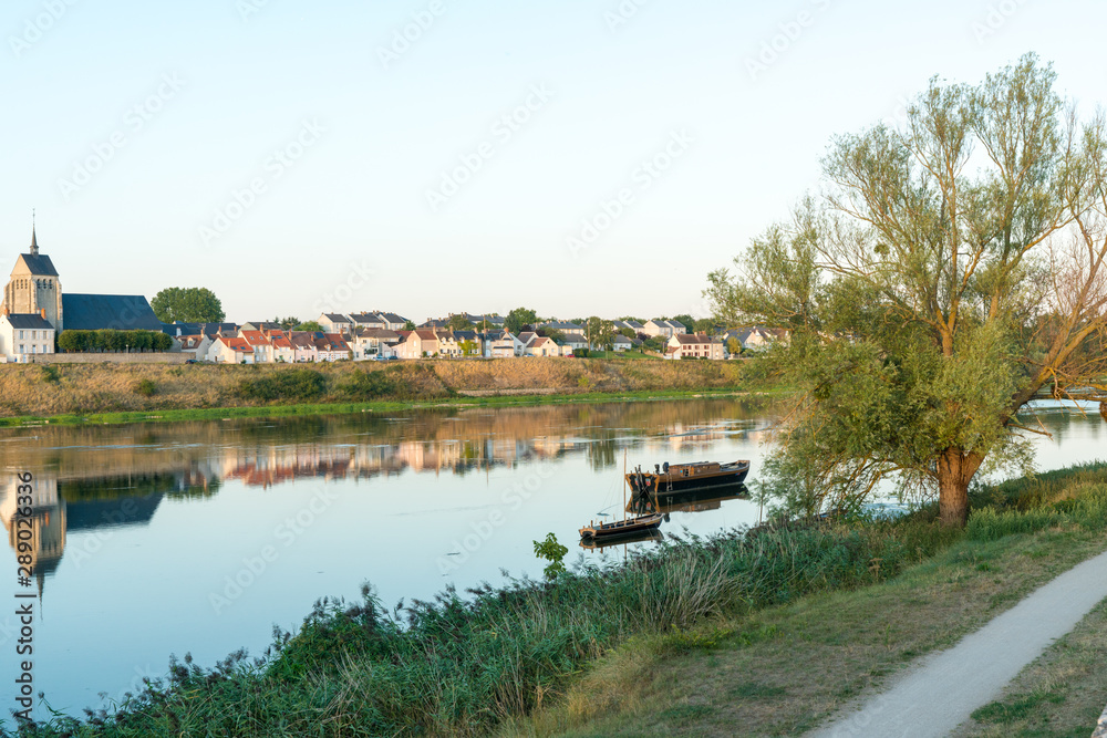 picturesque smalltown of Jargeau in the French countryside on the Loire river with riverboats in the foreground