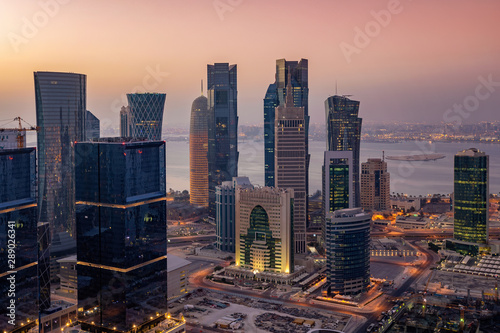 Das City Center mit den beleuchteten Wolkenkratzern von Doha in Katar bei Sonnenaufgang photo