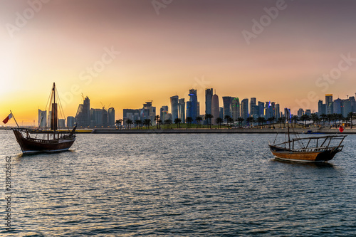 Blick über die Bucht von Doha mit den traditionellen Dhow Booten auf die markante Skyline bei Sonnenuntergang, Katar
