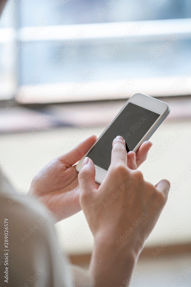Φωτογραφία スマートフォンを操作する女性の手元