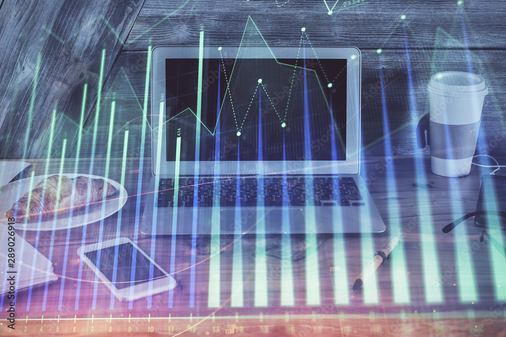 Financial graph colorful drawing and table with computer on background. Double exposure. Concept of international markets. Financial graph colorful drawing and table with computer on background. Double exposure. Concept of international markets.