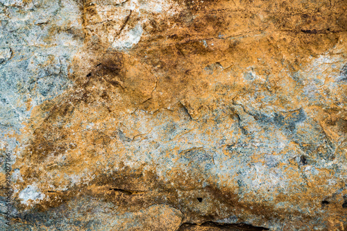 The texture of the stone overgrown with moss. Background image of a boulder