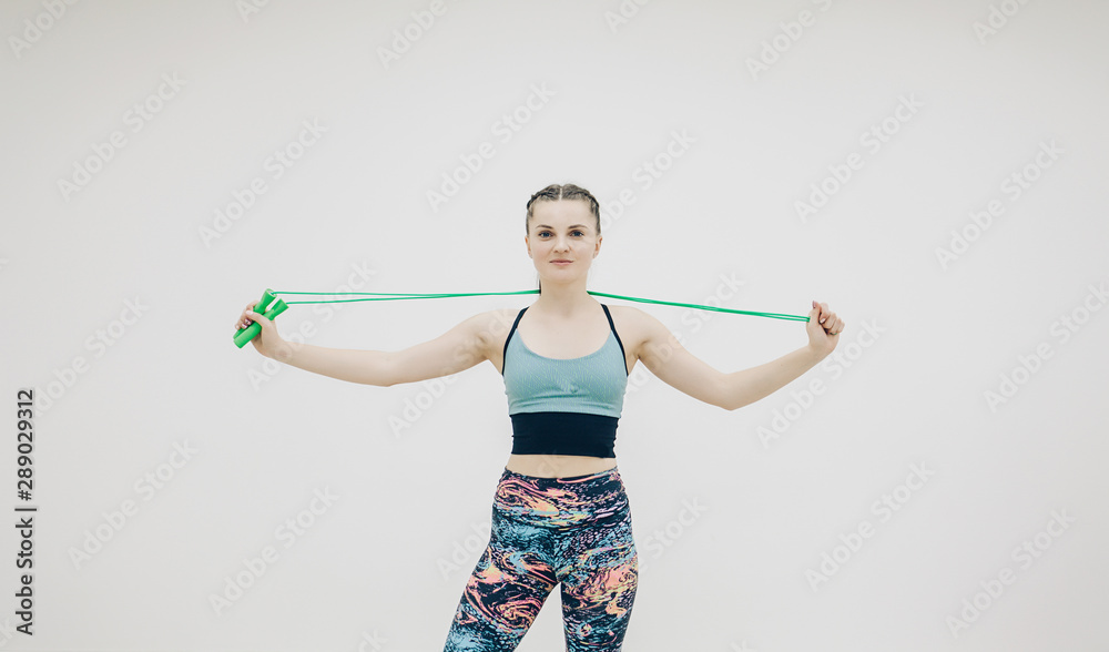 sports girl doing a warm-up with a rope before training