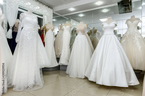 Collection of wedding dresses in showcase of the shop