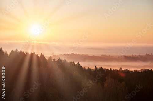Morning landspace with sun rays. Beautiful landscape with forest and fog.Lithuanian landscape.