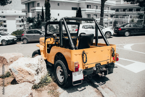 Desert ride sports openroof yellow orange car on the street. Offroad and hunting concept. photo