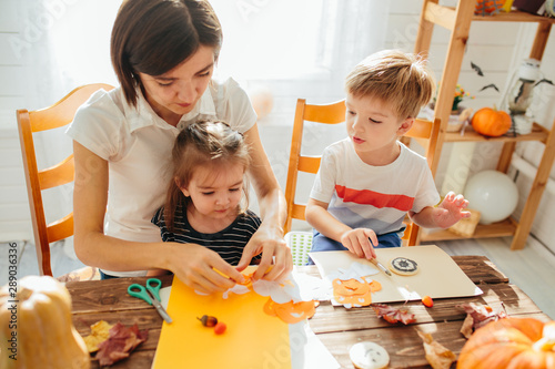 Happy family of mother and children prepare for Halloween pumpkins decorate the home Happy Halloween concept