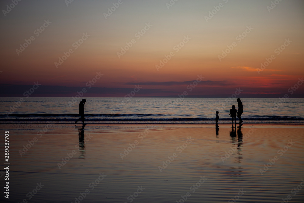 family silhouette on the beach