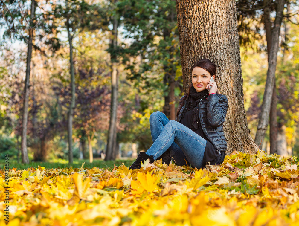 Woman on a Mobile in a Forest in the Autumn Woman on a Mobile in a Forest in the Autumn