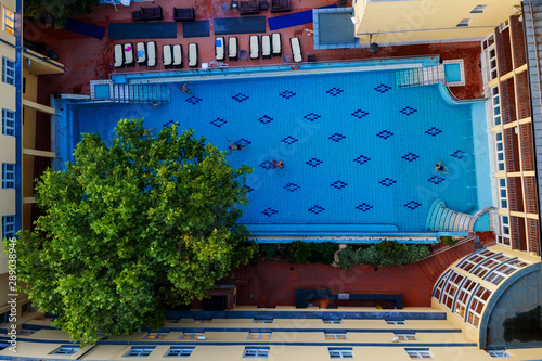 Swimming pool in the houseyard with a big tree. photo