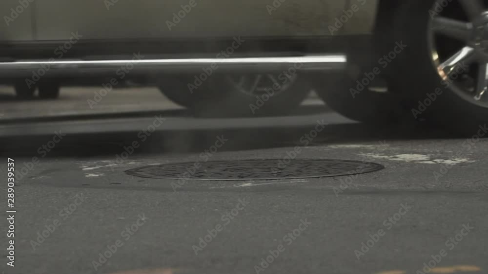 A slow motion shot of cars driving over a steaming manhole in central Boston. Shot in 120fps HD. A slow motion shot of cars driving over a steaming manhole in central Boston. Shot in 120fps HD.