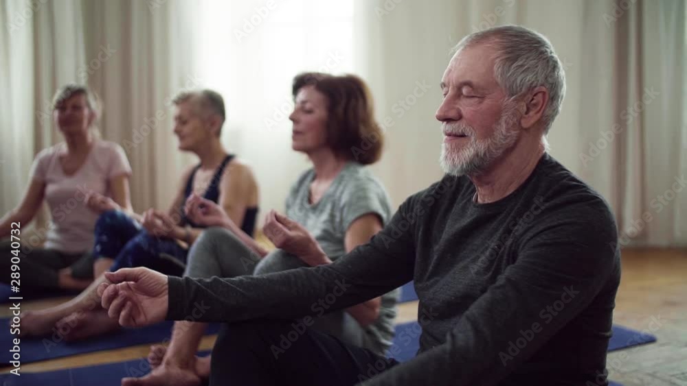 Group of senior people doing yoga exercise in community center club. Group of senior people doing yoga exercise in community center club.