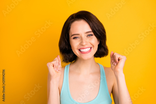 Photo of pretty sweet girl having evidently won some contests while isolated with yellow background